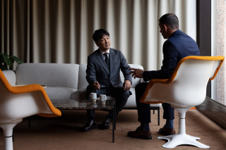 Two business professionals in discussion during a meeting, photograph.